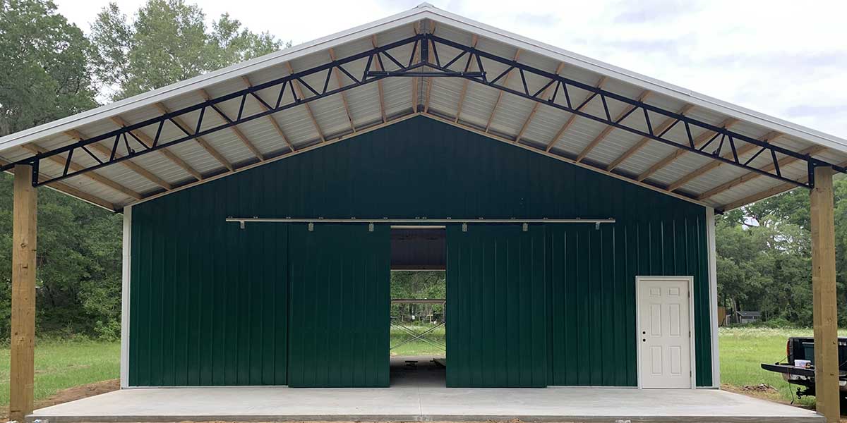 Green agricultural pole barn with open gable